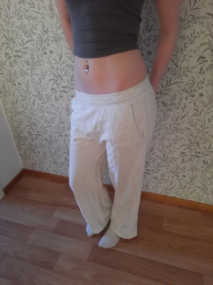 Ljusgrå mjukisbyxor med fickor - Säljer ett par ljusgrå mjukisbyxor med avslappnad passform och bred resår i midjan. Byxorna har två sidofickor och är tillverkade i mjukt, stretchigt material som passar perfekt för chill dagar hemma. Klassisk och enkel design utan synligt märke.