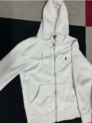 Vit hoodie från Polo Ralph Lauren - Säljer en vit hoodie ifrån ralph lauren, den är i jätte fint skick och är äkta! Den är inte använd något och kommer inte till användning mer, skriv till mig vid frågor🥰