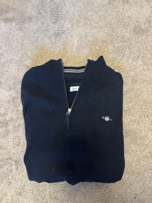 Gant Quarter Zip - Mörkblå Quarter zip från Gant. Storlek 170 som passar XS i vuxenstorlek. Inga hål och inga tydliga fläckar. Hör gärna av dig vid frågor eller prisförslag.