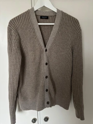 Beige  kofta från Massimo Dutti - Snygg beige ribbad kofta från Massimo Dutti. Perfekt att slänga över en t-shirt för en chill look nypris ca 800kr och knappt använd.