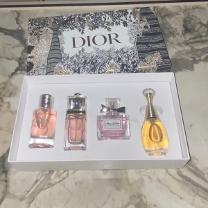 Dior parfymset med fyra miniflaskor 4x30ml - Lyxigt parfymset från Dior med fyra miniflaskor i olika former och färger. Setet innehåller klassiska dofter i eleganta glasflaskor, levereras i en vacker presentask med guld- och svartmönster. Perfekt för dig som vill testa flera Dior-parfymer.