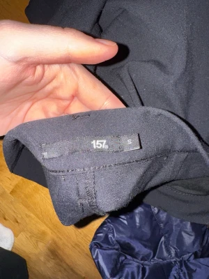 Svarta byxor från 157, raka ben - Säljer ett par svarta byxor från 157 med raka ben och enkel design. Byxorna har en klassisk passform och är tillverkade i ett mjukt tyg som känns bekvämt. Perfekta för dig som gillar stilrena och minimalistiska plagg.