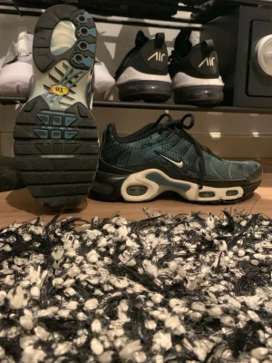 Nike tns svarta/blå sneakers - Skorna är väldigt snygga och bra till den som är sportig sitter perfekt på fötterna inte så mycket sönder förutom under skon och annars så är de i bra skick. Men där vid hälen är lite mjukare än vanligt men det är inte något som påverkar. 
