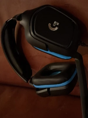 Logitech G gaming headset svart/blå - Säljer ett Logitech G gaming headset med sladd, i svart och blått. Over-ear design med mjuka, fyrkantiga öronkuddar och justerbar mikrofon. Perfekt för gaming och voicechatt. Snygg och robust design med tydlig G-logga på kåporna.