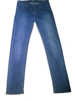 Blå selvage jeans från Lee - Säljer ett par selvage jeans från Lee med slim passform och fem fickor. Jeansen har knappgylf och Lee-logga på bakfickan. Strl 31:34 i modellen daren 