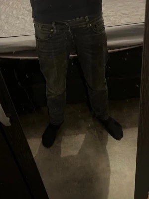 Mörkblå jeans från Jack & Jones - Snygga svarta jeans från Jack & Jones med klassisk femficksdesign och diskreta sömmar på bakfickorna. Jeansen har en rak passform och är tillverkade i stretchigt denim för extra komfort. Perfekta för en stilren och avslappnad look. Dom är helt nya har använts 3 gånger och jag säljer dom för att dom passade inte