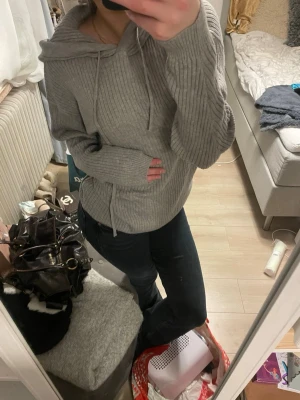 Grå ribbad hoodie med huva - Säljer en grå ribbad hoodie med huva. Tröjan har en avslappnad passform och långa ärmar. Materialet känns mjukt och bekvämt. Den är storlek XS från lager 157. 