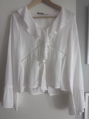 Vit volangblus från Kappahl - Söt vit blus från Kappahl med volangdetaljer. Säljer då den inte kommer till användning. Helt ny och priset går att diskutera.❤️