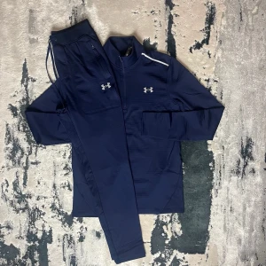 UNDER ARMOUR - FLEECED CW TRACKSUIT - Under Armour – Fleeced CW Tracksuit • Kofta och byxa i matchande färg • Storlekar från XS till 2XL • Går också att få på sneaks,se