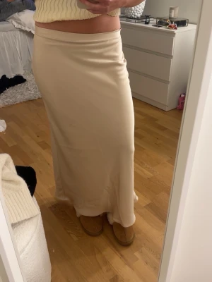 Beige lång kjol i satin - Så fin beige satin kjol från Zara som jag sprätt upp kanten på för att få den längre. Så lappen är borta men skulle säga xs/s. Några små små fläckar men inget man tänker på