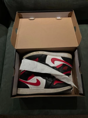 Air Jordan 1 Retro svart/röd/vit - Säljer nu mina Jordan 1s, säljer pågrund av att jag växte ut dom för ett tag sen och inte använt dom så mycket. Dom är äkta och är i storlek 40.