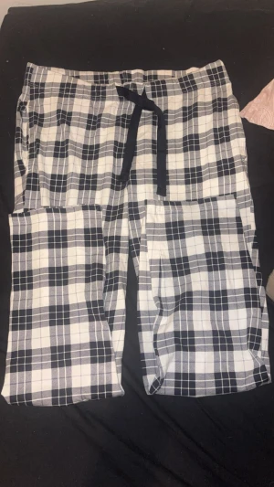 Rutiga pyjamasbyxor i blått och vitt - Mysiga pyjamasbyxor med blåvitt rutmönster och justerbar midja med svart snöre. Perfekta för chillkvällar hemma. M men passar som S om man knyter hårt, är 1,70cm lång och passar perfekt.