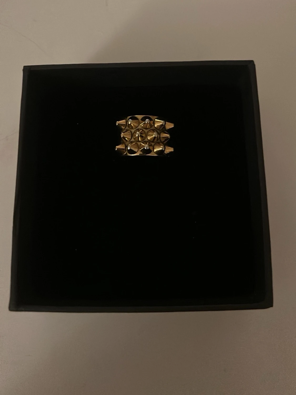 Guldfärgad edblad ring med nitar