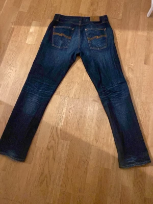 Mörkblå jeans från Nudie Jeans - Säljer ett par mörkblå jeans från Nudie Jeans med klassisk femficksmodell och raka ben. Jeansen har snygga fades framtill. Modellen är Sharp Bengt och är nästan säker på att dom inte tillverkas längre. Riktigt feta och sköna! Storlek W31 L33