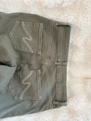 Gröna jeans från Nelly - Jag säljer ett par gröna jeans med vita detaljer på fickorna i bak. De är ny köpta och är i nytt skick, aldrig använts. Dessa är i storlek 40 och jag säljer de för de är för stora för mig. 