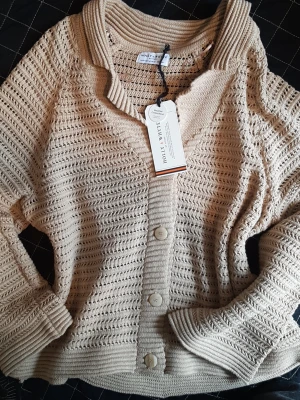Ny beige kofta från Holly and Whyte  - Brand new, beige, light cappuccino coloured cardigan. Size L. 60% cotton. 