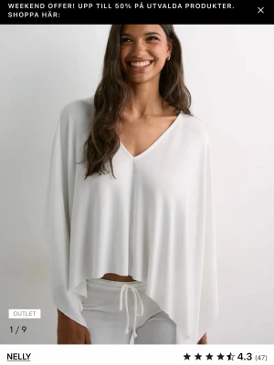 Vit v-ringad topp från Nelly - Luftig vit topp från Nelly med v-ringning och lång ärm. Modellen är croppad med lös passform och tillverkad i ett mjukt material som ger ett avslappnat intryck. Perfekt för en stilren och enkel look.