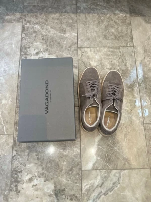 Vagabond sneakers mocka - Snygga grå sneakers från Vagabond i mjuk mocka med vita sulor och klassisk låg design. Storlek EU44 använd enstaka gånger. Köpta av mig i Stockholm.