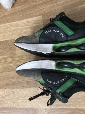 Nike Air Max svarta och gröna sneakers - Nike Air Max sneakers i svart och grönt med vita detaljer. Skorna har en synlig Air Max-sula i grönt och svart, mesh- och syntetmaterial på ovandelen samt klassisk Nike-logga på sidan. Snygg och sportig design med lågt skaft och snörning.