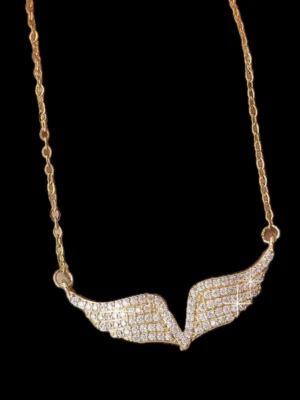 Guldhalsband med vinge och stenar - Snyggt halsband i guldton med ett hängsmycke format som en vinge, täckt av glittrande små stenar. Kedjan är tunn och elegant, perfekt för att ge din outfit lite extra bling. Perfekt accessoar för dig som gillar unika smycken med detaljer.