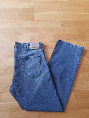 Levi's Denizen  - Klassiska blå jeans från Denizen Levi's med rak passform och fem fickor. Jeansen har en ljusblå tvätt, normal midja och är gjorda i slitstark bomullsdenim. Perfekta för en avslappnad och tidlös stil.