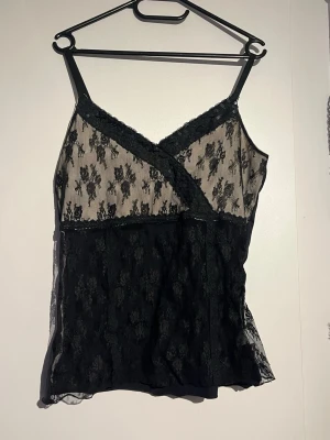 Svart spets top med blommönster🖤 - Svart linne top🖤 Med coverage därbak men bara spets därframm🖤 Perfekt för dig som gillar en feminin och trendig look🖤den va utan tyg under spetsen jag tror personen som sålde den klippte av tyget därframme 🖤