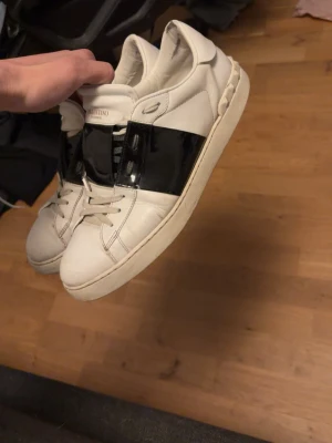 Valentino vita sneakers med svart detalj - Säljer dessa feta opens dom är lite sällsynta med de svarta glansiga inte många som använder säljer billigt vill bli av med dom st 44 hör av er om ni har frågor 