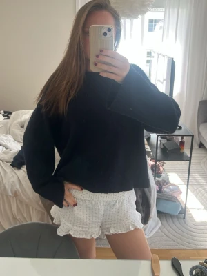 Svart oversized stickad tröja - Mysig svart stickad tröja med oversized passform och långa ärmar. Tröjan har en enkel design utan synliga loggor eller mönster, perfekt för en avslappnad och trendig look. Passar till både jeans och kjol.