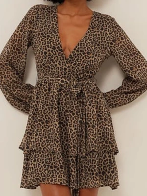 Leopardmönstrad omlottklänning NAKD - Snygg kort leopardmönstrad omlottklänning från NAKD med v-ringning, långa ärmar och knytband i midjan. Klänningen har volangdetaljer och är tillverkad i ett lätt, transparent material som ger en cool look.