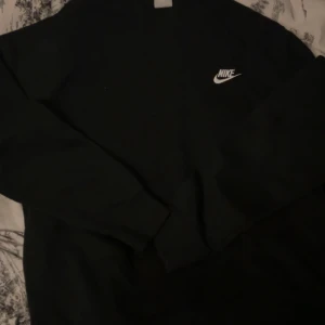 Svarta Nike mjukisbyxor - Säljer ett par svarta mjukisbyxor från Nike med klassisk logga på höften. Byxorna har en avslappnad passform och är gjorda i mjukt material som är perfekt för chill dagar. Elastisk midja och muddar vid benslut ger en skön känsla.