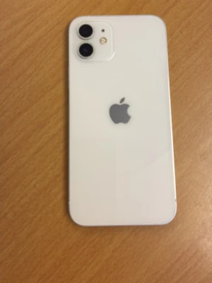 Vit iPhone 12 med dubbla kameror - Säljer en vit iPhone 12 med stilren design och två kameror på baksidan. Telefonen har en glasbaksida, aluminiumram och den klassiska Apple-loggan. Skärmen är stor och täcker nästan hela framsidan, perfekt för sociala medier och streaming. Batteri kan behöva bytas då den dör efter några timmar Face ID är även trasigt