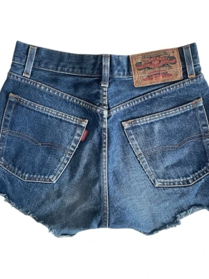  Denimshorts från Crocker  - Blåa jeansshorts med bruna sömmar och fram- och bakfickor. Material: 100 % bomull Midja: 73 cm Längd: 30 cm Längd: 28,5 cm | Jag brukar vanligtvis ha strl S! 