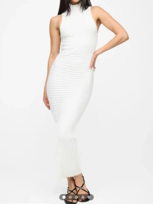 Vit ribbad långklänning - Supersnygg vit långklänning med ribbad struktur och ärmlös design. Klänningen har en hög hals och figurnära passform som framhäver siluetten. Perfekt för dig som gillar stilrena och trendiga plagg.