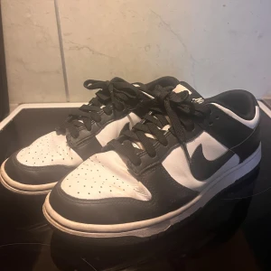 Nike Dunk Low svart/vit sneakers -  Nike Dunk Low svartvita sneakers. Storlek 41, innermått 26cm. I använt men bra skick.