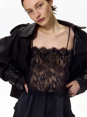 Svart spetslinnetopp med tunna band - Snygg svart linnetopp med tunna axelband och transparent spets upptill. Toppen har en volangkant nedtill och vacker spetsdetalj både fram och bak. Perfekt för dig som gillar en trendig och elegant look.