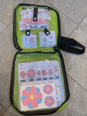 Majblommor 2026 komplett säljsats - Armband med Majblomman i blått och rosa med gul mitt. Blomman är platt och sitter på ett enkelt band. Perfekt accessoar för dig som vill visa stöd och samtidigt ha en färgglad detalj. Materialet är lätt och passar de flesta handleder.