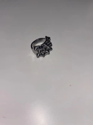 Edblad ring - Cool ring i silverfärgad metall med flera utstickande nitar runt hela ringen. Perfekt accessoar för dig som gillar en edgy och alternativ stil. Ringen har en bred design och är riktigt iögonfallande.