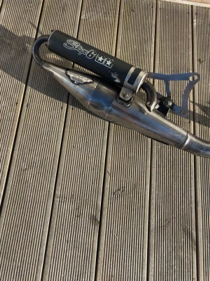 Yasuni Z avgassystem till moped med stage 6 ljuddämpare - Säljer ett yasuni Z avgassystem med stage 6 ljuddämpare för moped. Utrustad med svart ljuddämpare med vit stage 6 logga. Tillverkad i metall med kromad finish och svetsade fogar. Passar perfekt för dig som vill uppgradera din moppe. Avgasröret är även ny polerat där jag ägnat mycket tid att polera avgassystemet. Avgassystemet har suttit på en Yamaha aerox och även passar liggande minarelli motor. Jag säljer avgasröret eftersom att jag behöver ett starkare rör. Perfekt för dig som vill små trimma