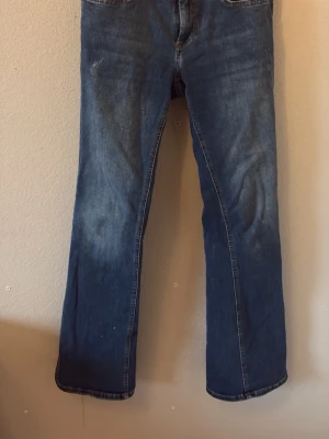 Blå bootcut jeans  - Säljer ett par klassiska blå bootcut jeans från Only med snygga slitningar och kontrastsömmar. Jeansen har en rak passform med låg midja och är tillverkade i slitstark denim. Perfekta för dig som gillar en avslappnad och tidlös look. För mer frågor är det bara att dma💞