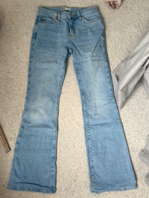 Ljusblå bootcut jeans - Säljer ett par ljusblå bootcut jeans från Gina i stlk 32, de har tyvärr blivit för små därav att jag säljer. Så snygg blå färg och perfekt till våren! Inga defekter! 