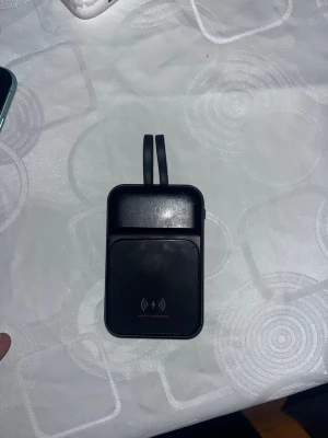 MagSafe  - Magnetisk powerbank med trådlös laddning och 20000mAh kapacitet. Utrustad med både USB-C och Lightning-kabel, perfekt för laddning av flera enheter. Några mindre repor och märken syns, men i gott skick och fullt fungerande.