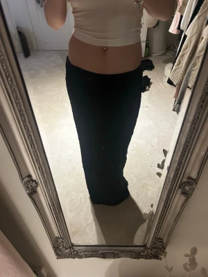 Svart långkjol i mjukt material - Säljer en svart långkjol med rak passform. Kjolen är i ett mjukt, strukturerat tyg som känns skönt mot huden. Perfekt att styla med crop tops eller stickade tröjor för en clean look.