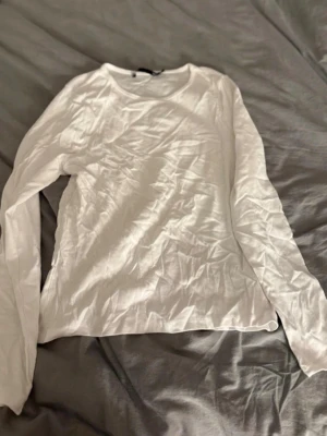 Vit och svart långärmad topp från 157 - En basic vit och svart långärmad topp från 157 med rund halsringning. Tillverkad i mjuk bomull som känns skön mot huden. Perfekt att styla lager på lager eller bära som den är. Enkel och clean design som passar till allt.