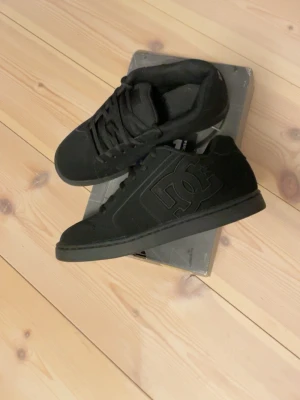 Svarta DC sneakers - Säljer ett par helsvarta DC sneakers med klassisk låg profil och tydlig DC-logga på sidan. Snygga och otroligt sköna skor! Har använt ca 3 gånger.