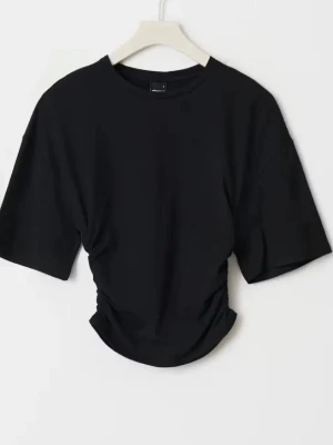 Svart croppad t-shirt med snörning - Snygg svart croppad t-shirt med snörning i sidan och korta ärmar. Perfekt till jeans eller kjol för en trendig look. Tillverkad i mjuk bomull som känns skön mot huden. Enkel men ändå unik detalj med rynk vid midjan.