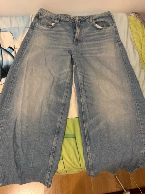 Ljusblåa wide leg jeans - Säljer ett par ljusblåa jeans med riktigt breda ben och klassisk femficksdesign. Jeansen har hög midja och en avslappnad passform, perfekta för en trendig och bekväm stil. Materialet är denim i bomull och de har en snygg tvättad look.