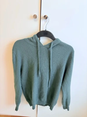 Grön hoodie fån st studios - Mysig grön hoodie från st studios i 100% Kashmir, ny pris 1299kr men säljs nu för endast 349kr!. Perfekt för en chill och enkel stil. Storlek S är väldigt skön och varm