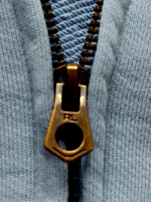 Ljusblå Ralph lauren zip hoodie  - Ljusblå Ralph lauren zip hoodie size 150 (12-14) Den är äkta och i mycket fint skick och sparsamt använd. Den mäter 54 cm i längd och 41 cm i bredd. Den har två knappt synbara minifläckar på vänstra ärmen, jag säger detta ifall någon undrar.                                                                  Hör av er om ni har några frågor kring tröjan!