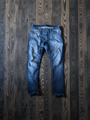 Blå slitna skinny jeans - Säljer ett par blå slim tiger of sweden jeans med slitningar och tvättade detaljer. Jeansen har  femficksdesign.