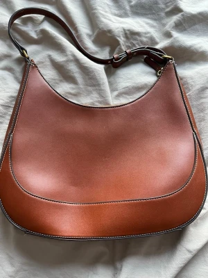 Brun väska! - INTRESSEKOLL! Superfin brun väska från Mango🥰Har en liten fläck inuti men det är som sagt inuti och inget som förstör väskans skick🥰Axelväska